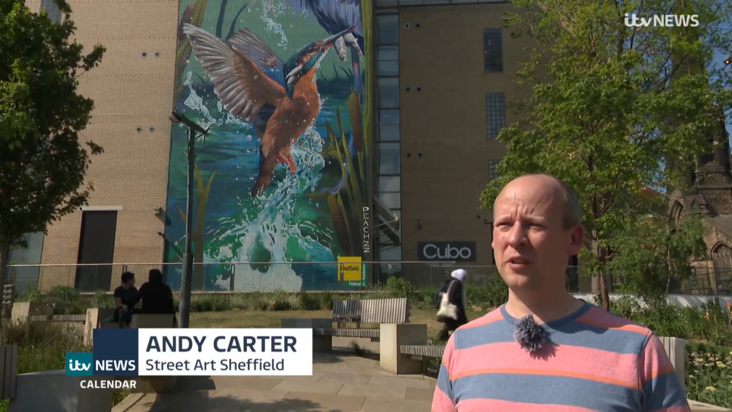 Andy being interviewed in front of a colourful mural of a kingfisher, an on-screen graphic for ITV News Calendar displays Andy Carter's name and affiliation to Street Art Sheffield